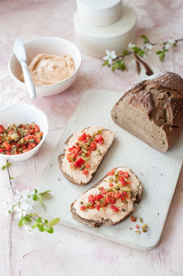 liptauer spread on a piece of bread, half the bread, bowl with topping, bowl with the spread