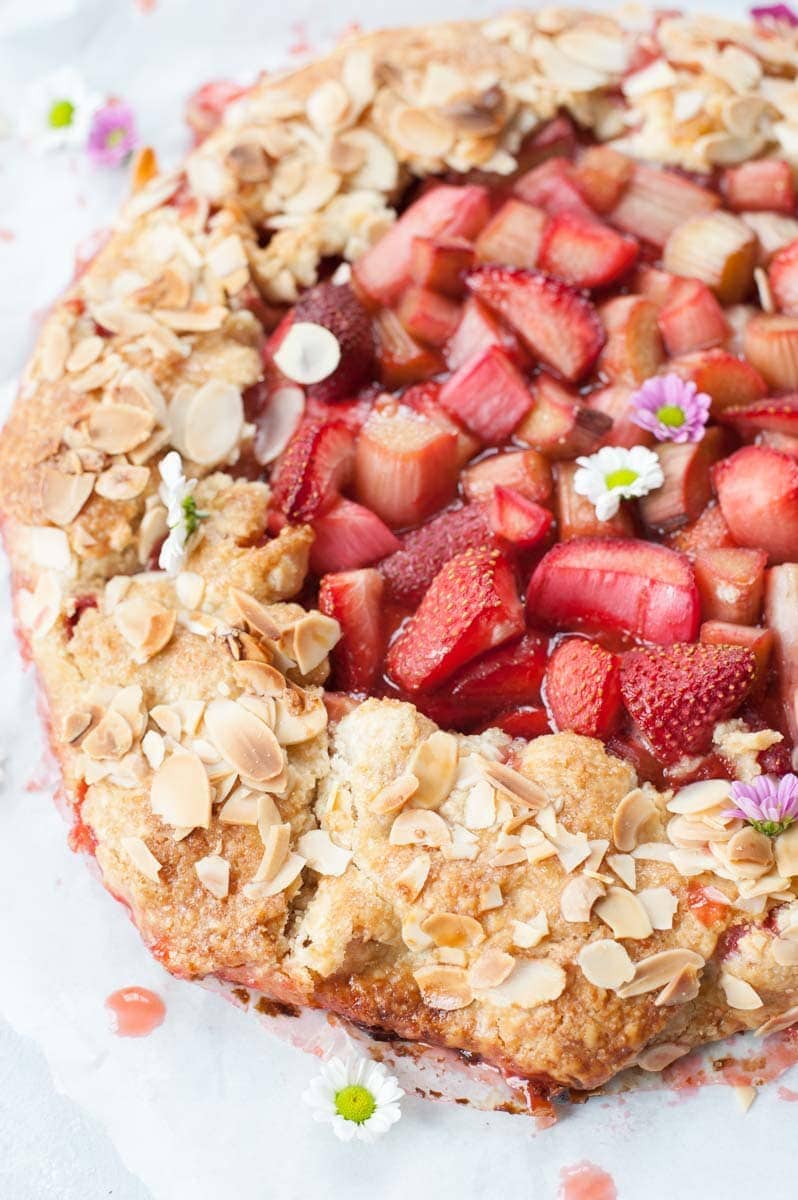 Close up photo of strawberry rhubarb galette with flaked almonds on top.