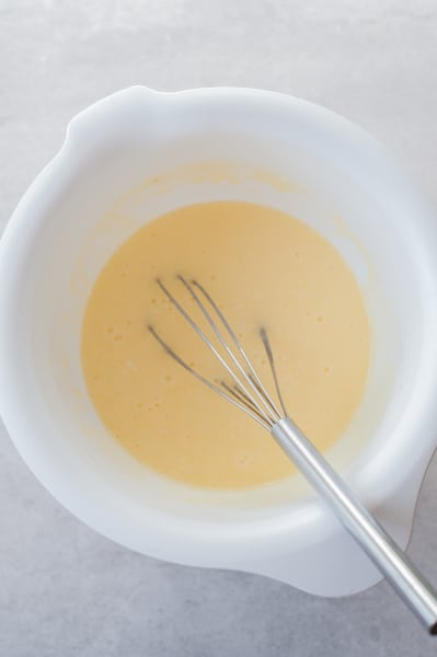 mixed wet ingredients for mango muffins in a bowl