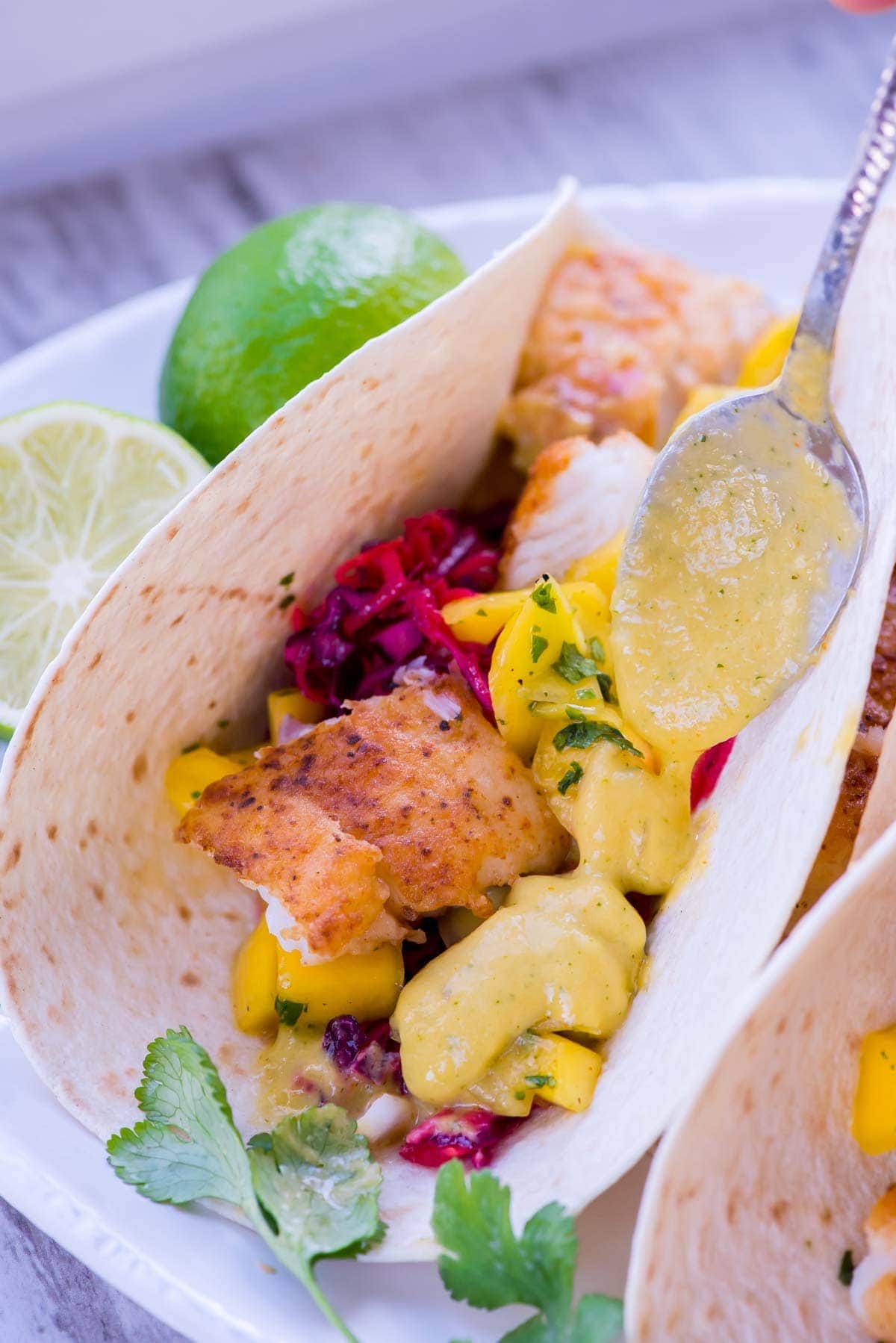 Fish tacos with mango salsa on a plate.