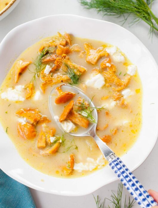 Chanterelle mushroom soup in a white bowl.