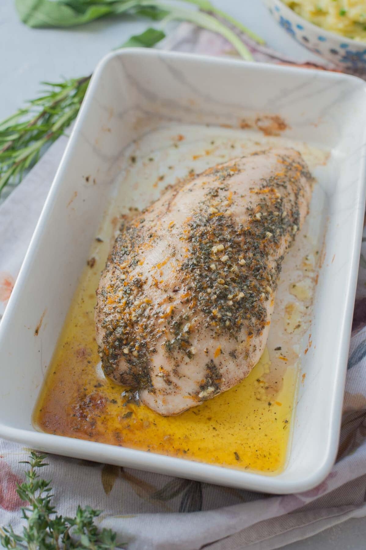 Baked turkey tenderloin in a white baking dish.