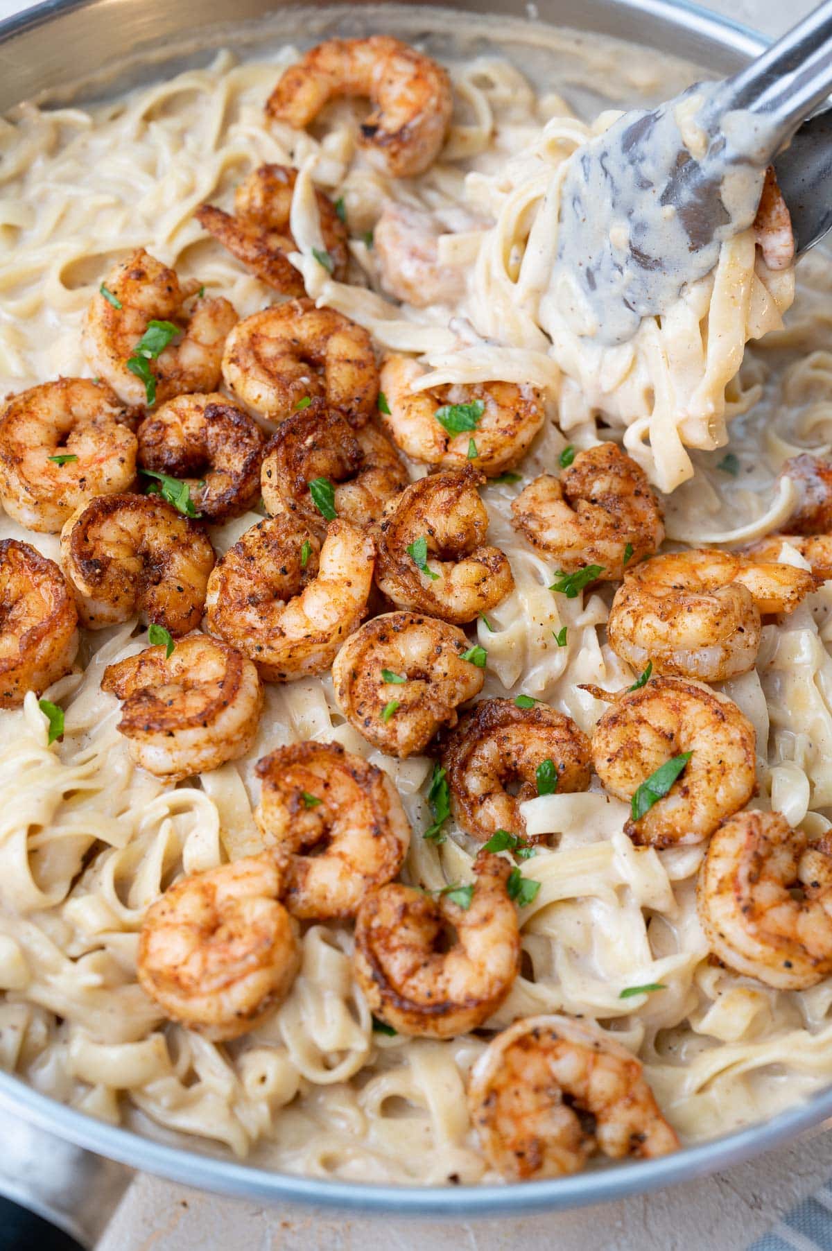 Cajun shrimp alfredo in a frying pan-.