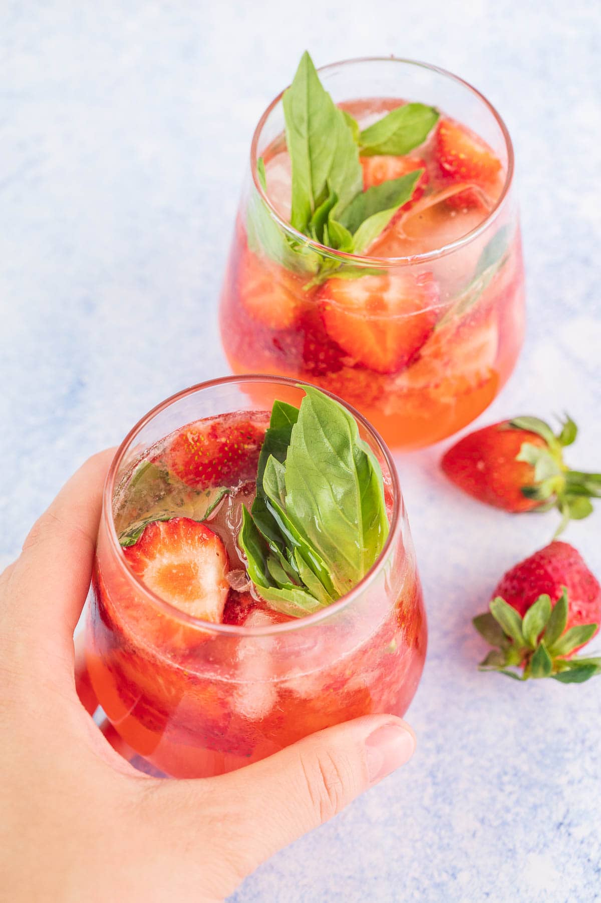 Two glasses with strawberry basil vodka cocktail.