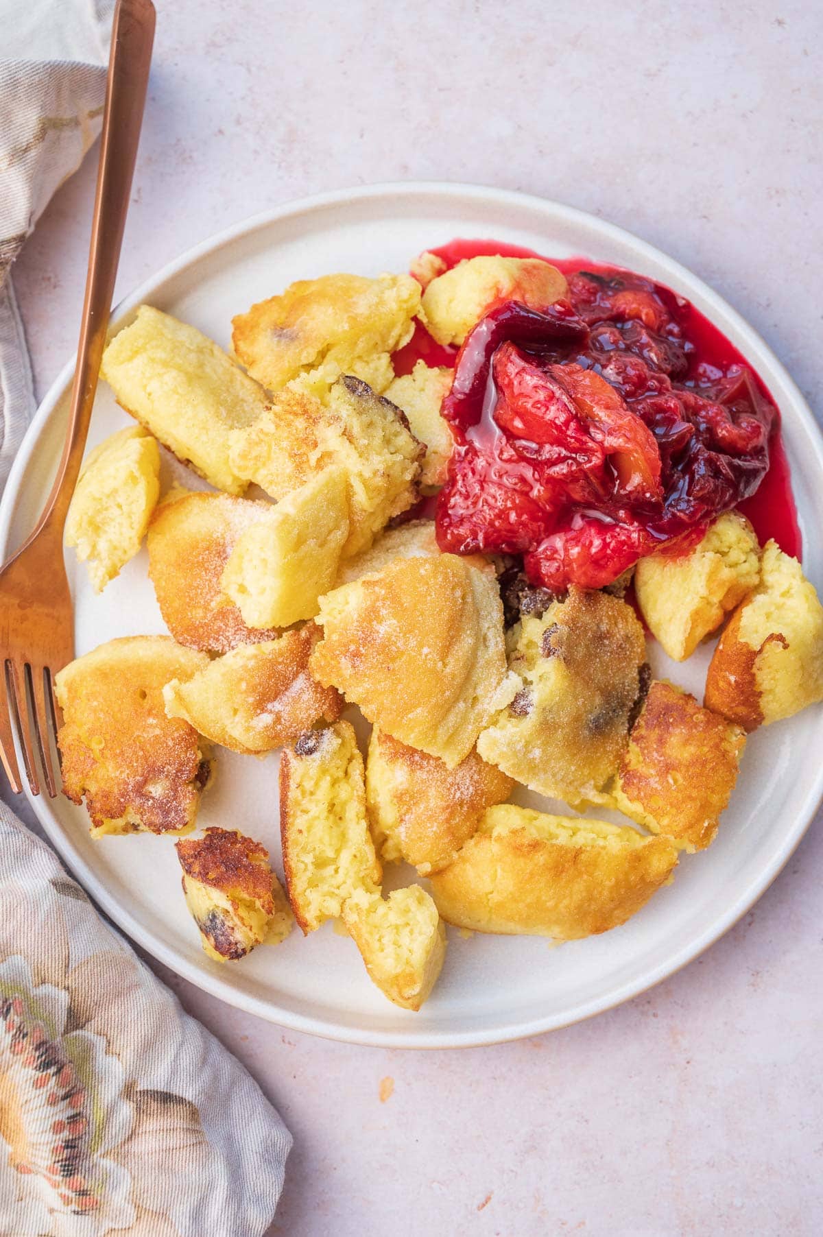 Kaiserschmarrn served with plum compote on a white plate.