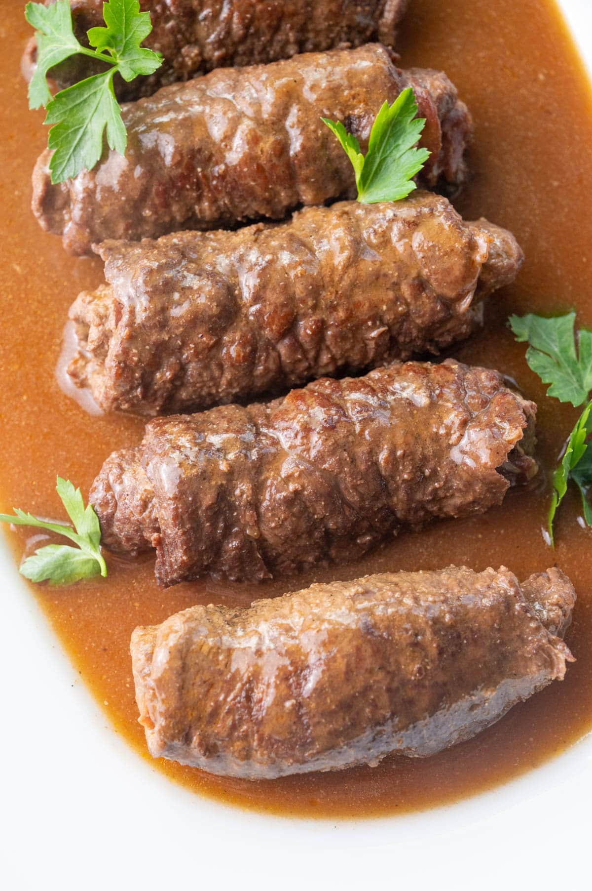 Rouladen with gravy on a white plate.