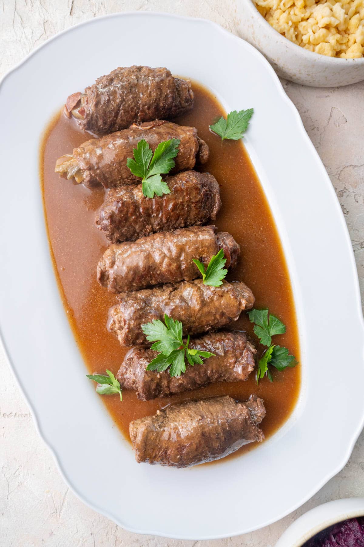 Rouladen rolls with gravy on a large white plate.