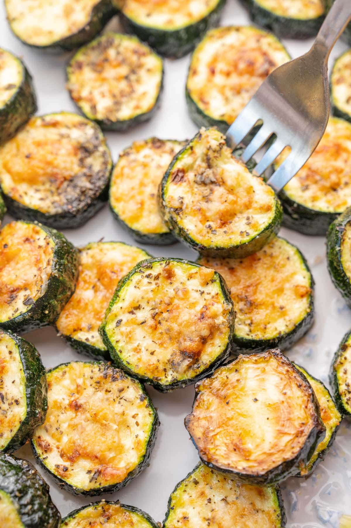 Baked parmesan zucchini rounds on a baking sheet.