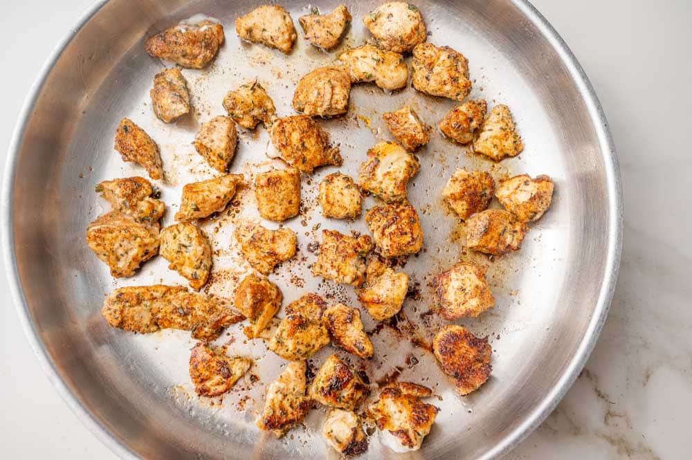 Pan-fried diced chicken in a frying pan.