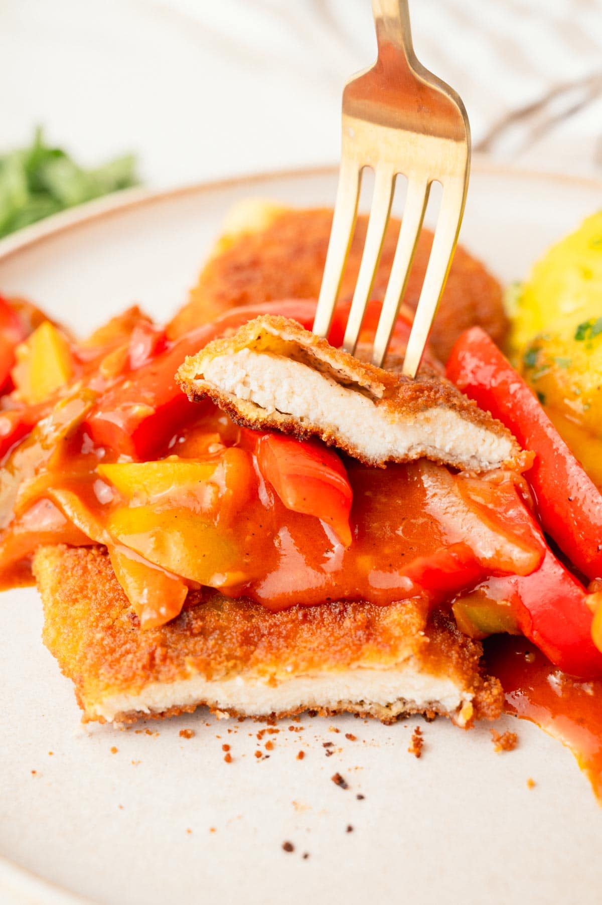 Schnitzel with bell pepper sauce on a beige plate.
