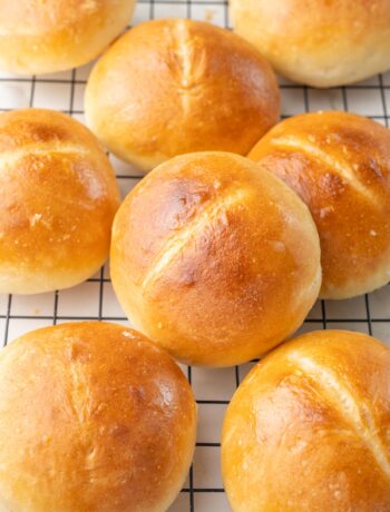 Brötchen bread rolls on a black cooling rack.