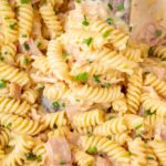 A close-up photo of German pasta dish Schinkennudeln in a white pot.